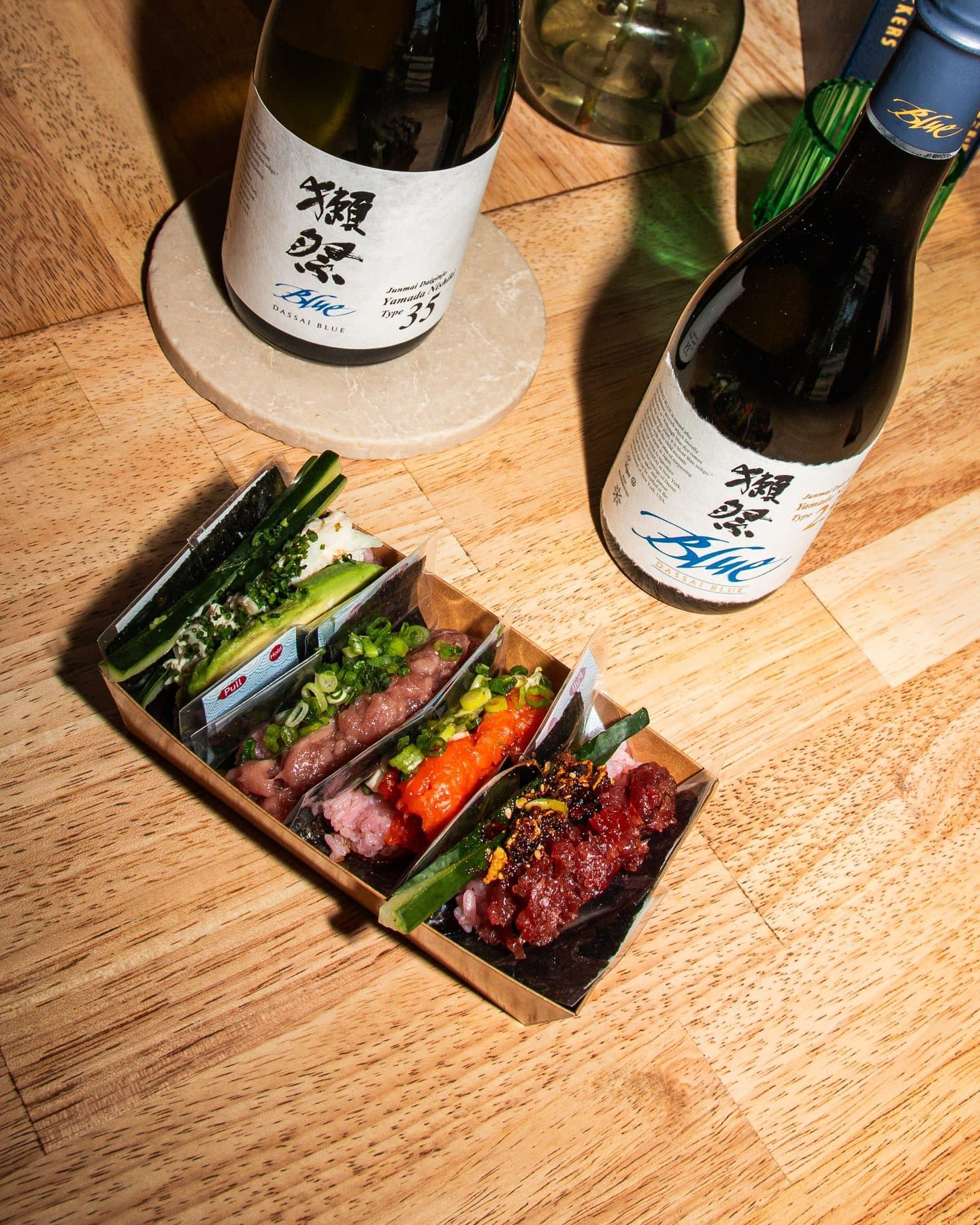 A box of hand-cut handrolls with Dassai sake at Kitsu Nori